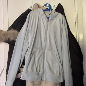 Ljusblå kofta från Gina Tricot XL - Säljer en ljusblå kofta från Gina Tricot i storlek XL. Tröjan har dragkedja framtill, huva utan snörning och två stora fickor.