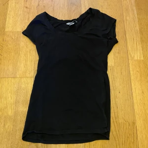 Svart kortärmad topp från H&M - En enkel svart topp från H&M i mjuk pima bomull. Modellen är rak med rund halsringning och korta ärmar. Perfekt att matcha med jeans eller kjol för en clean look.