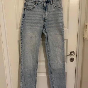 Ljusblå straight jeans -  ljusblå jeans från H&M &Denim i rak modell med medel midja. Klassisk femficksdesign och regular fit. Jeansen är tillverkade i denim och har en snygg vintagekänsla med ljus tvätt. Använd en gång. Storlek 38. 