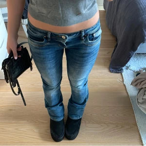 Blåa lågmidjade jeans - Super snygga blåa lågmidjade jeans i storlek w28 L32 från ltb. Materialet är stretchigt och skönt. Passformen är bootcut och de är perfekta införa hösten och vintern! Mått: Tvärs över är det 40 cm och innerbenslängden är 78 cm.