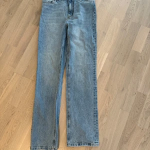 Blå raka jeans från Vero Moda - Klassiska blå jeans från Vero Moda med rak passform och normal midja. Jeansen är tillverkade i denim och har en enkel design utan slitningar eller detaljer. Perfekta för en avslappnad och stilren look.