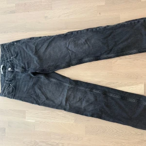 Svarta jeans från Zara - Snygga svarta jeans från Zara med klassisk femficksdesign och raka ben. Jeansen har en mörk tvätt och är tillverkade i bomull med en skön passform. Perfekta för dig som gillar en enkel och stilren look.