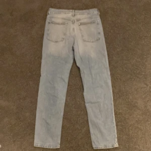 Ljusblå relaxed  jeans från H&M - Ljusblå jeans från H&M med relaxed fit och justerbar midja. Modellen har tapered ben och klassisk femficksdesign. Perfekta för dig som gillar en avslappnad men ändå snygg stil. Jeansen är i bomull och har en lätt tvättad look. Modellen är 169cm lång