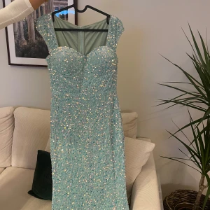 Ljusblå långklänning med paljetter - Superfin ljusblå långklänning med glittrande paljetter över hela klänningen. Dragkedja i ryggen för enkel påklädning. Klänningen är helt ny och inte använt. 