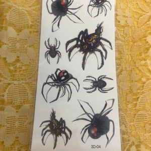 Tillfälligt Tatuering  - Ark med smyckestatueringar i svart och silver, med motiv av hjärtformade lås, kedjor, kors och små blå blommor. Perfekt för att skapa en edgy och cool look med detaljerade och stilrena smyckesmotiv. 29kr/st 