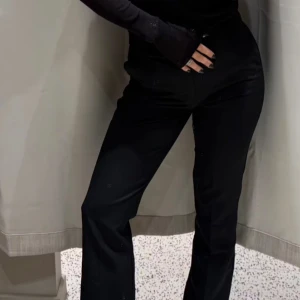 Svarta kostymbyxor från BikBok - Snygga svarta kostymbyxor från BikBok i klassisk rak modell. Byxorna har hällor för bälte och stängs med dragkedja och knapp. Perfekta för en clean och stilren look, passar till allt och är superenkla att matcha.