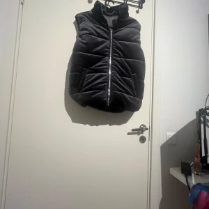 Svart quiltad dunväst i sammet - Säljer denna eftersom att jag har en annan jag använder mer. Den är perfekt nu till hösten.