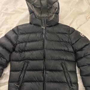 Svart pufferjacka från Colmar - Säljer en svart pufferjacka från Colmar med huva och två dragkedjeförsedda fickor. Jackan har en quiltad design och tydlig logga på ärmen. Perfekt för kalla dagar och riktigt snygg till streetwear-stilen. Nypris 4500kr. Samma bilder och jacka är även ute på blocket för att få sålt snabbare! Detta är lägsta pris