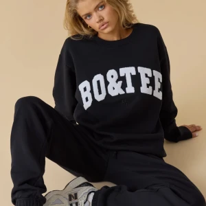 Svart sweatshirt från Bo&tee - Svart oversized sweatshirt från Bo&tee med stora vita bokstäver framtill. Perfekt för en chill och sportig look. Säljer eftersom den inte används❤️