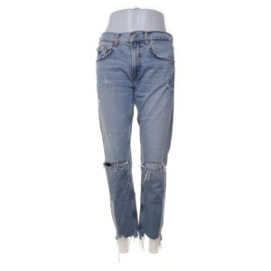 Blå ripped jeans från Zara, strl 38 - Snygga ljusblå jeans från Zara med slitna detaljer och hål vid knäna. Modellen har rak passform, klassisk femficksdesign och fransade benslut. Perfekta för dig som gillar en avslappnad och trendig streetstil.