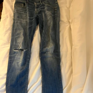 Blå slitna jeans från Dondup Ritchie - Säljer ett par blå jeans från Dondup, modell Ritchie. De har snygga slitningar och bra pass form