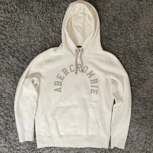 Abercrombie Hoodie - Säljer nu denna sjukt snygga hoodien från Abercrombie! Den är i storlek S men sitter något större. Mycket bra skick utan defekter! Färg: Vit/Cremefärgad, riktigt fet! Hör av dig vid frågor eller funderingar!