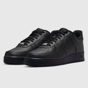 Nike Air Force 1 helsvart - Nike Air Force 1 i helsvart färg med klassisk siluett. Skorna har en platt sula, rund tå och är tillverkade i skinn med perforerade detaljer på tån för extra ventilation. Snygga snörningar och ikonisk Swoosh på sidan. Perfekt för dig som gillar stilrena sneakers. Fråga om ni vill ha bilder 
