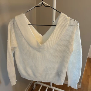 Vit stickad v-ringad tröja ONLY - Säljer en vit stickad tröja från ONLY med djup v-ringning och bred krage. Tröjan har lång ärm och ribbad struktur, perfekt för lager på lager. Enkel att styla och supermysig till höst och vinter.