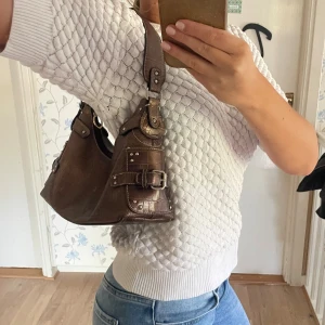 Brun väska med detaljer - Fin brun väska med detaljer. Väldigt unik och trendig 