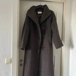 Lång brun kappa - ”High Collar Belted Coat” från Nelly, helt oanvänd med prislapp på! Slut på hemsidan just nu!!! Säljer då den var för stor för mig, NYPRIS 999kr