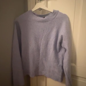 Ljuslila stickad tröja med rund hals - Supermysig ljuslila stickad tröja med rund halsringning och långa ärmar. Perfekt för kyliga dagar och enkel att matcha med jeans eller kjol. Tröjan har en avslappnad passform och ribbade muddar vid ärmslut och nederkant. Stolek S passar även xs 