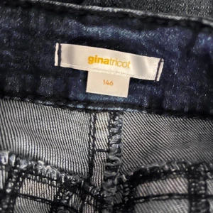 Mörkblå jeans från Gina Tricot stl 146 - Snygga mörkblå jeans från Gina Tricot i storlek 146. dekorativa bakfickor med guldiga knappar och markerade sömmar, otroligt snygga🩷🤍
