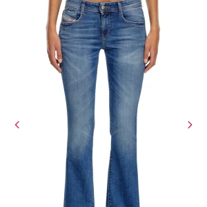 Blå bootcut jeans från Diesel - Snygga blå jeans från Diesel med bootcut passform. Jeansen har låg midja och är tillverkade i mjukt denim med slitningar och ljusare partier framtill. Jeansen är uppsydda några centimeter längst ned, kolla 3:de bilden. Perfekta för dig som gillar en avslappnad men trendig look.