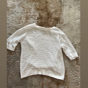 Vit stickad tröja från 157 - Säljer en vit stickad tröja från 157 med snyggt hålmönster. Perfekt till jeans eller kjol för en fräsch look.