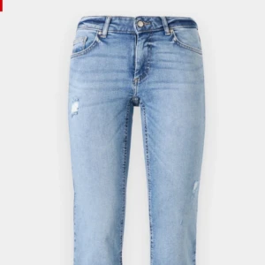 Ljusblå bootcut jeans med slitningar - Snygga ljusblå jeans med bootcut passform och diskreta slitningar på låret och knät. Klassisk femficksmodell med bälteshällor och dragkedjegylf. Jeansen har en lätt tvättad look och är perfekta för en avslappnad stil. Storleken är S34