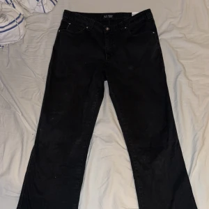 Svarta jeans från Armani Jeans - Svarta jeans från Armani Jeans med klassisk femficksdesign och snygg broderad logga på bakfickan. Jeansen har raka ben och normal passform, tillverkade i mjukt bomullsmaterial. Perfekt för dig som gillar stilrena och tidlösa plagg.