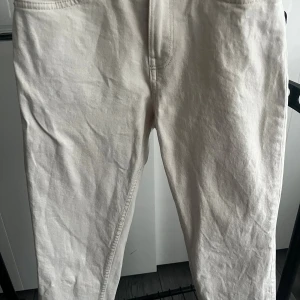 Vita raka jeans i bomull  (Pris kan diskuteras!) - Snygga vita jeans med klassisk femficksdesign och raka ben. Jeansen har bälteshällor, silverfärgad knapp och dragkedja. Tillverkade i bomull för en skön känsla och stilren look. Perfekta för dig som gillar en clean och enkel vibe.  Används bara 1 gång (de har blivit för små på mig tyvärr) 