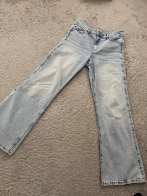 Ljusblå wide jeans från Perfect Jeans - Säljer ett par ljusblå jeans från Perfect Jeans i storlek 42. De har en relaxed wide fit med raka ben och klassisk femficksdesign. Jeansen är tillverkade i mjukt denimtyg och har en snygg tvättad look som passar till allt.