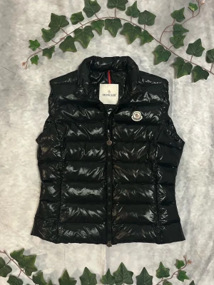 Moncler Ghany Vest – Svart – Strl 3 (M) - |Färg: Svart, blank | Modell: Ghany, quiltad | Storlek: 3 (M), normal passform | Skick: Grade A, 10/10 | Hör av dig ifall du har funderingar!