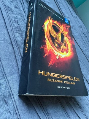 Hungerspelen av Suzanne Collins - Hungerspelen, del 1, av Suzanne Collins. Perfekt för dig som gillar spännande dystopiska berättelser. Pocketformat, tryckt av Bonnier Carlsen.
