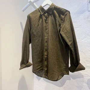 Olivgrön linneskjorta Oscar Jacobson - Olivgrön skjorta från Oscar Jacobson i storlek M, tillverkad i linne. Sitter slimfit. Snygg och bekväm