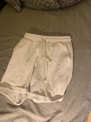 Vita sweatshorts från AMISU - Vita mjuka sweatshorts från AMISU med elastisk midja och snörning. Shortsen har en avslappnad passform och är tillverkade i bomull, perfekta för chill dagar. Klassisk design utan mönster eller extra detaljer. Jättesköna och väldigt uppdelade av folk! Efterfrågade!!😅🙏🏼