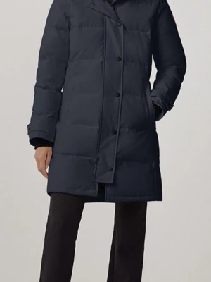 Svart  lång dunjacka Canada Goose - Snygg mörkblå dunjacka från Canada Goose med lång passform och diskret logga på ärmen. Jackan har dragkedja och knappar framtill, quiltad design och långa ärmar. Perfekt för kalla dagar och riktigt varm.