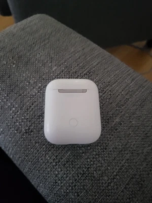 Vita trådlösa hörlurar AirPods - Säljer ett par vita trådlösa hörlurar från Apple, AirPods, med laddningsetui. Snygg och kompakt design i blank plast, perfekt för musik, poddar och samtal. Laddningsetuiet har en smidig magnetisk stängning och LED-indikator.