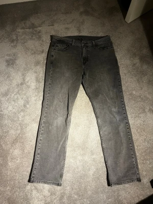 Grå Levis 511 jeans straight fit - Säljer ett par grå Levis 511 jeanshwlt oanvända  med klassisk straight fit och femficksmodell. Jeansen har normal midja och är tillverkade i slitstark bomullsdenim. Perfekta för dig som gillar en tidlös och avslappnad stil.