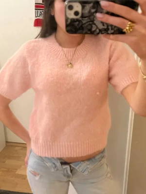 Ljusrosa stickad kortärmad tröja - Supersöt ljusrosa stickad tröja med korta ärmar och ribbade kanter. 