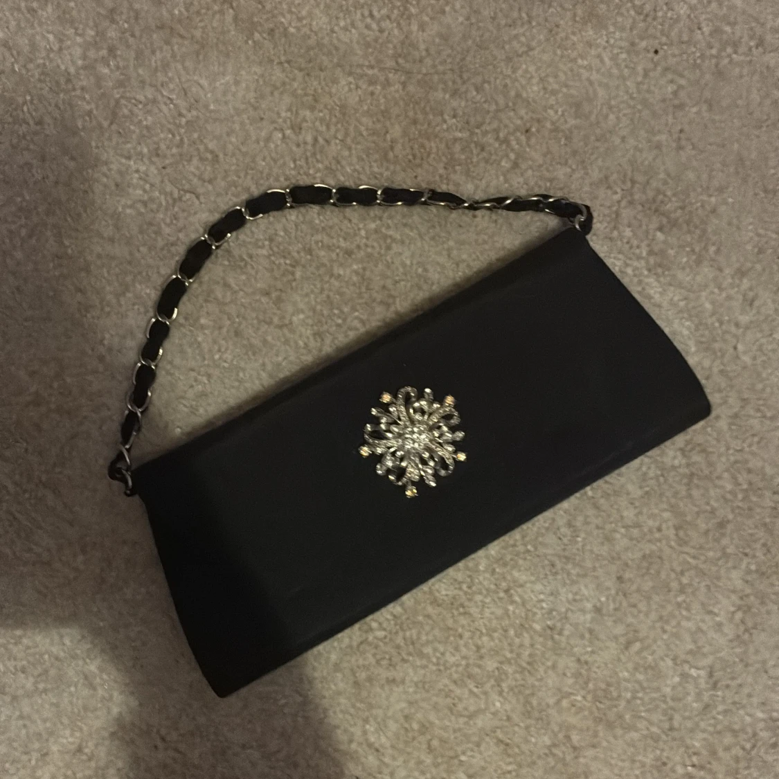 Svart kuvertväska med kedja och smycke