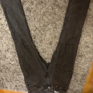 Svarta jeansbyxor Regular Fit - Svarta jeansbyxor från Denim med klassisk Regular Fit-passform. Byxorna har rak siluett och normal midja, tillverkade i slitstarkt jeanstyg. Perfekt för dig som gillar en enkel och tidlös look.