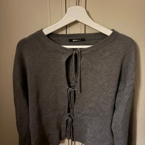 Grå kofta med knyt från Gina Tricot strl S - Säljer en grå kofta från Gina Tricot med snygga knyt framtill. Använd typ två gånger, superfint skick❤️ strl S,
