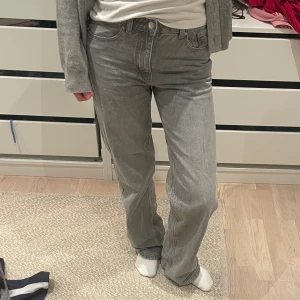 Gråa raka jeans med normal passform - Säljer ett par gråa jeans med vanlig och klassisk femficksdesign. Jeansen har en normal midja.