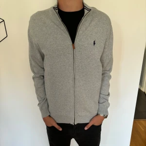 Ralph Lauren fullzip - Riktigt snygg raffe fullzip i storlek L. Modellen är 185. Den är i toppskick! Hör av dig vid minsta fundering!