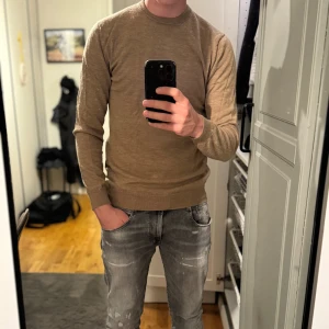 Beige stickad tröja från Matinique - Säljer en stilren beige stickad tröja från Matinique i storlek M. Tröjan har rund halsringning, långa ärmar och är tillverkad i merino ull. Bra skick