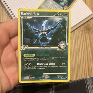 Darkrai Lv.58 - Cool och sällsynt Pokémonkort från 2009 med Darkrai, Team Galactic’s Pokémon. Kortet har specialförmågor som Eerie Aura och Darkness Sleep. Perfekt för samlare och fans av Pokémon TCG som vill ha något unikt i sin samling. Kvaliteten är helt okej.