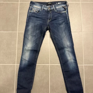 Replay jeans blå - Snygga Replay Luz jeans i mörkblå tvätt med slitningar och kontrastsömmar.  Med klassisk femficksdesign och Replay-logga på fickan. Perfekt passform för dig som gillar smala jeans med lite stretch. 26/30 storlek