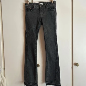 Svarta bootcut jeans från Gina tricot - Snygga svarta bootcut jeans från Gina med tvättad look och broderade bakfickor. Klassisk femficksmodell med knapp och dragkedja. Jeansen har en något utsvängd passform nertill och är tillverkade i mjukt jeanstyg.