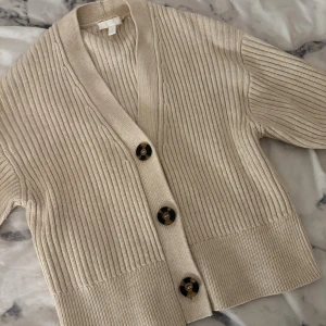 Stickad kofta - Beige stickad kofta med knappar från h&m i storlek xs.