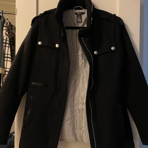 Svart jacka från Filippa K - Svart jacka från Filippa K.  Jackan har en krage. Materialet är ullblandning med polyester och viskosfoder. Perfekt för höst och vinter.