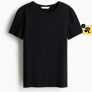 Svart ribbad t-shirt med rund hals - En stilren svart t-shirt med ribbad struktur och rund hals. Modellen är klassisk med korta ärmar och passar perfekt till jeans eller shorts. Materialet känns mjukt och följsamt mot huden, vilket gör den skön att bära hela dagen.