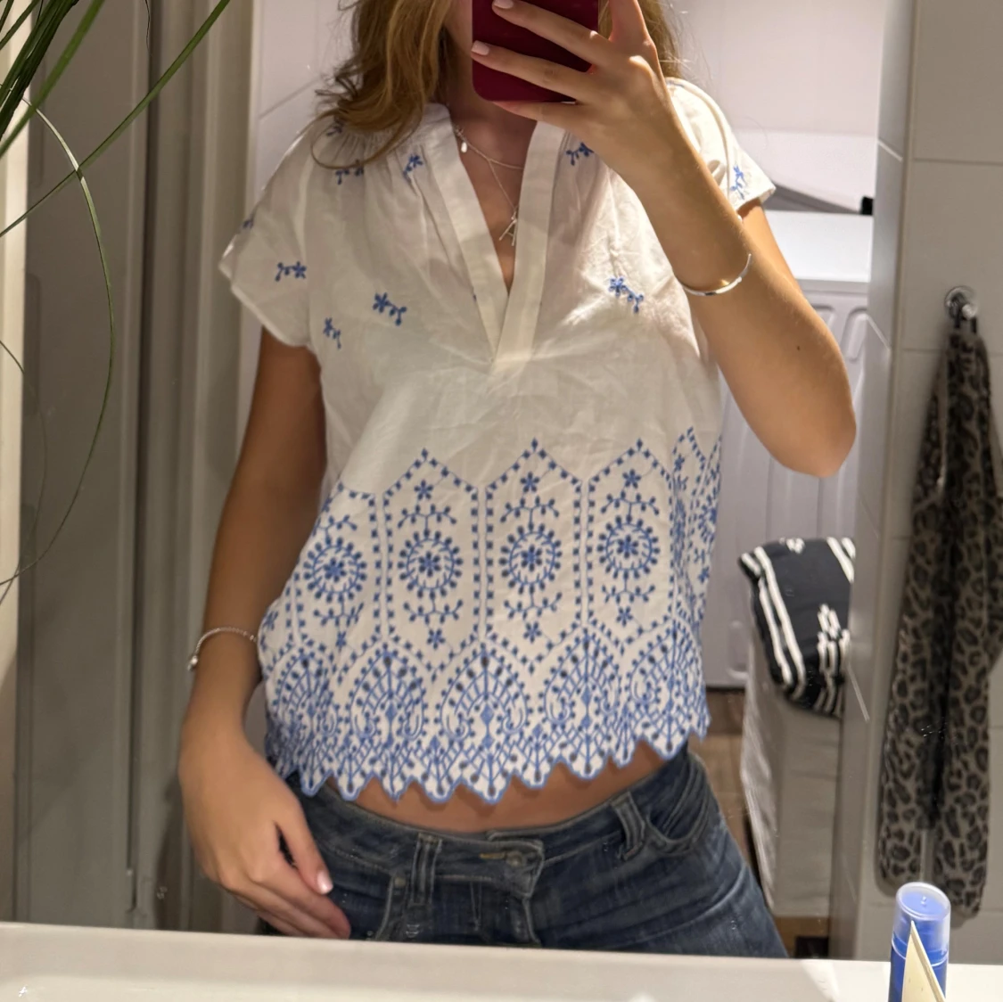 Vit blus med blå broderi och v-ringning