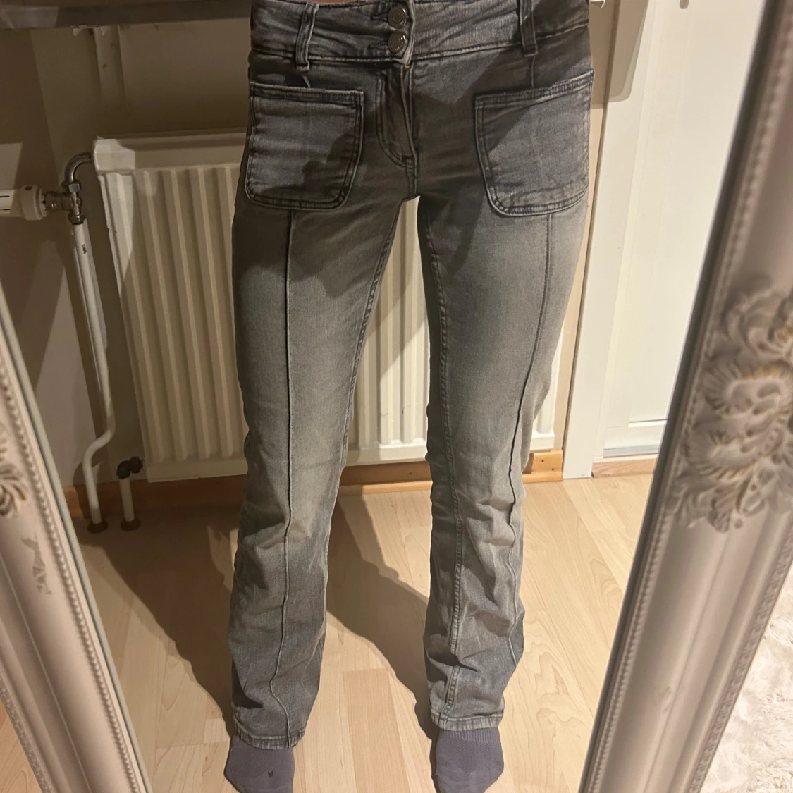 Gråa jeans med utsvängda ben och stora fickor